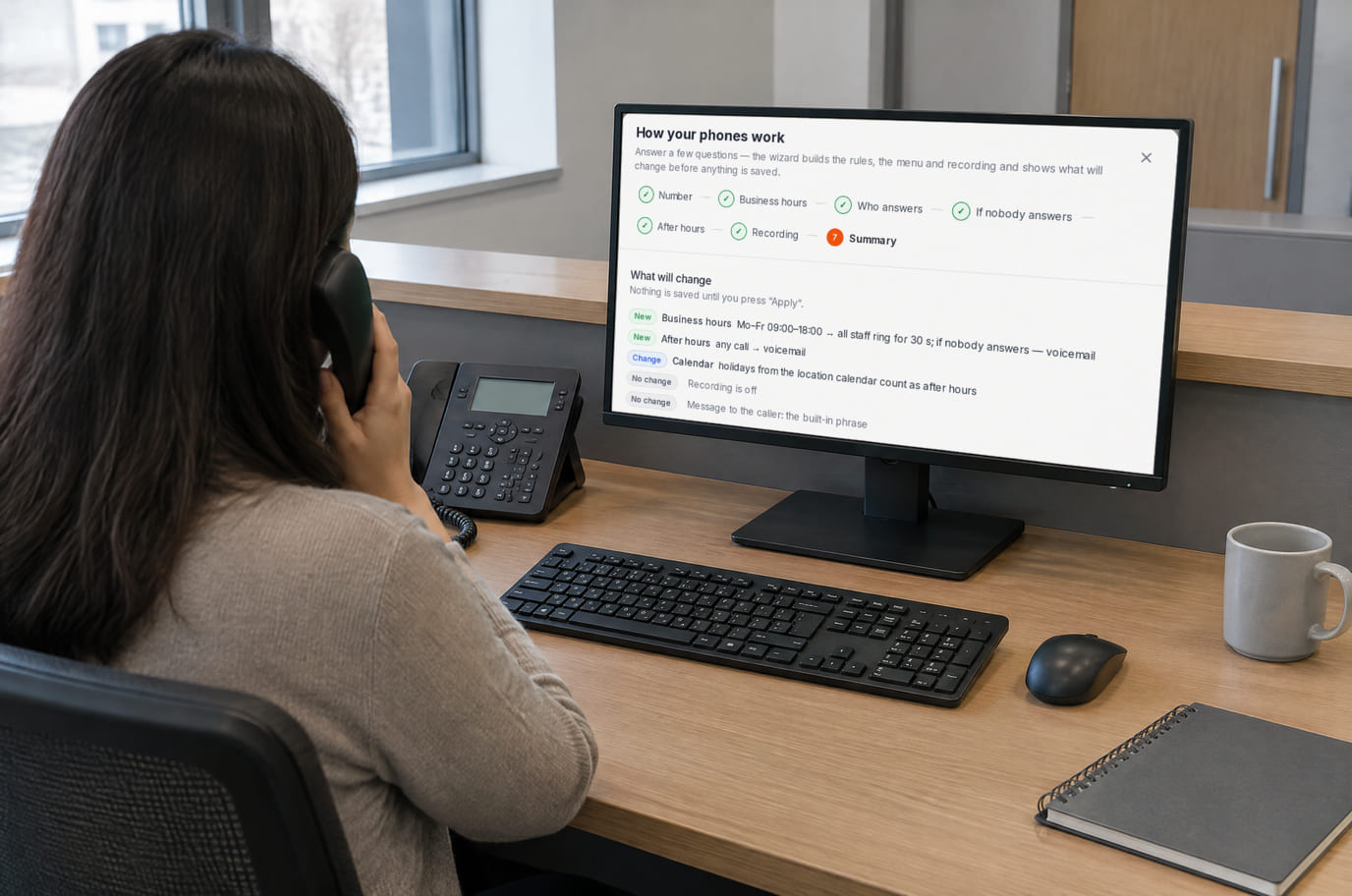 A receptionist on a desk SIP phone; the monitor shows the call rules: who answers in business hours and what happens without an answer